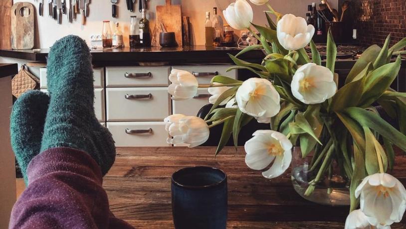 Personne se détendre dans une cuisine confortable portant des chaussettes en laine. Découvrez ce qu'est le mot danois Hygge
