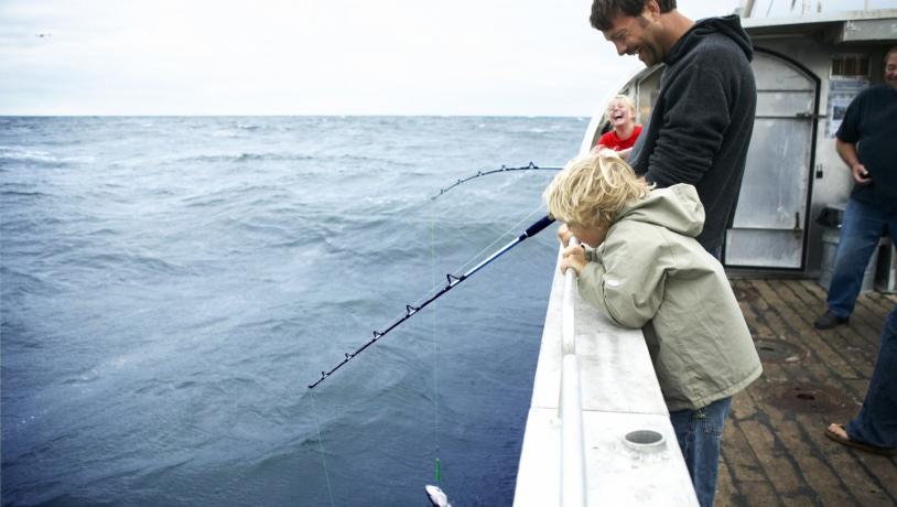 Family fishing from a boat in Denmark