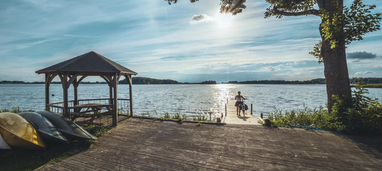 Woman with bike, taking a quick break along the N8 cycling route in Lolland-Falster, Denmark