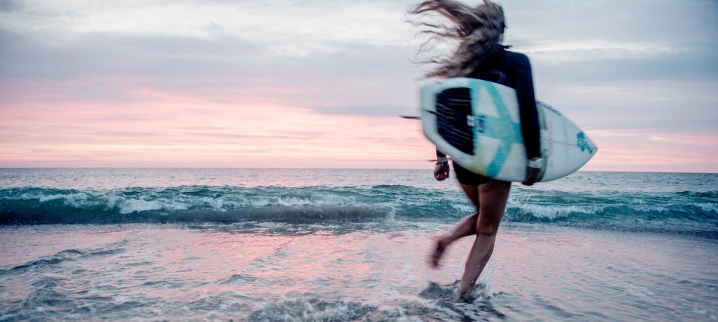 Surfer på stranden i Klitmøller Cold Hawaii på nordvestkysten av Danmark