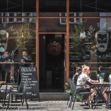 People eating on the street outside vegetarian restaurant We Feat in Aalborg, Denmark 