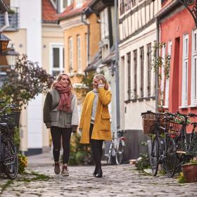 To venniner går sammen i den sjarmerende gaten, Hjelmerstald i Aalborg i Danmark
